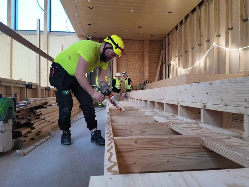 Person i arbeid med trebygg